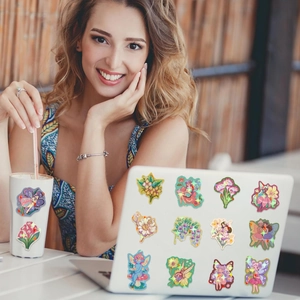Holographic fairy stickers on a laptop and water bottle showing waterproof decorative effects