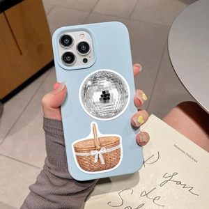 Close-up of a light blue matte iPhone case with disco ball and picnic basket stickers