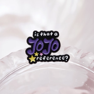 Detailed view of enamel pin with JOJO text and star motifs on a glass rim