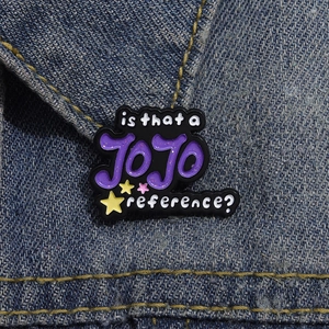 Detail of JOJO reference enamel pin with purple glitter on dark denim background