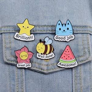 Set of five cute cartoon animal and fruit enamel pins with motivational text on denim jacket