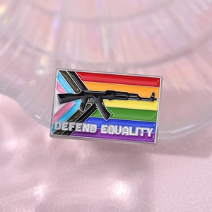 Rainbow progress pride flag enamel pin featuring a rifle silhouette and defend equality text