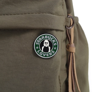 Detail of round green enamel pin with sunglasses lady on green canvas bag