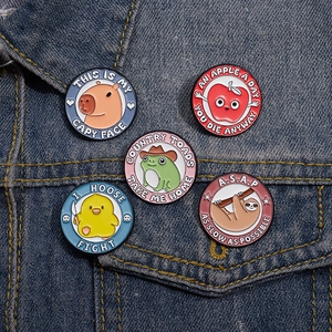 Detail of five cute cartoon animal enamel pins pinned on a blue denim jacket pocket