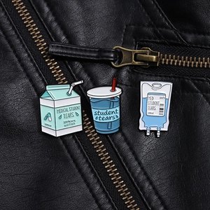 Detail of medical student tears enamel pin set on a black leather jacket texture