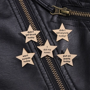 Detailed view of five gold star-shaped metal pins featuring humorous English quotes on leather