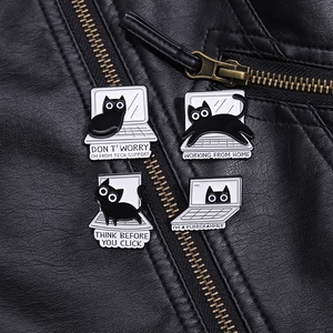 Detail of four funny cat enamel pins on a black leather jacket with tech support text