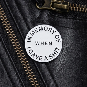 Detailaufnahme der runden Emaille-Anstecknadel mit sarkastischem Spruch auf Lederjacke