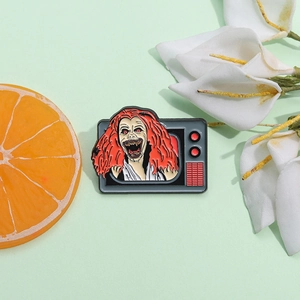 Cartoon enamel pin featuring a horror figure emerging from a vintage TV set