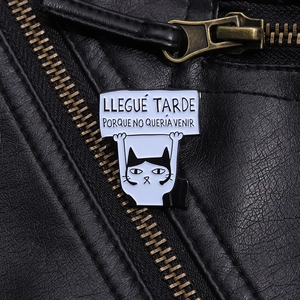 Minimalist cat enamel pin with Spanish text quote on a black leather jacket