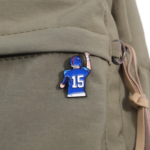 Detailed macro view of American football player number 15 enamel pin on a green canvas bag