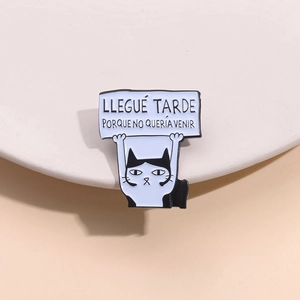 Detail view of cartoon enamel cat pin with Spanish text plate and polished finish