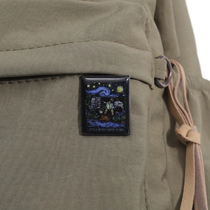 Detail of Van Gogh Starry Night enamel pin attached to a green canvas backpack