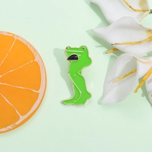 Broche en émail grenouille musclée aux longues jambes avec bords dorés et finition brillante