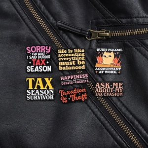 Détail de badges en émail avec slogans de comptabilité sur une veste en cuir noir