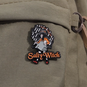 Detail of the Salty Witch enamel pin with girl holding umbrella on a canvas bag
