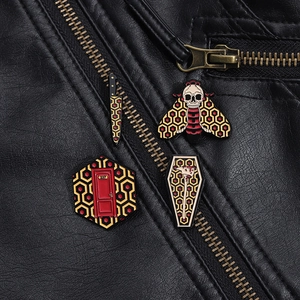 Detail view of The Shining themed enamel pins featuring Room 237 on black leather jacket