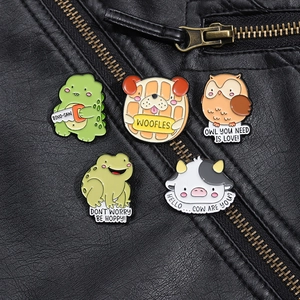 Détail de broches en émail aux motifs d'animaux rigolos sur une veste en cuir noir