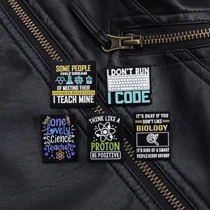 Set aus fünf Wissenschafts- und Coding-Emaille-Pins auf Lederjacke mit edlem Metallglanz