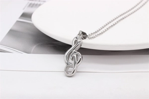 Detailed close-up of a silver musical note pendant on a fine stainless steel chain