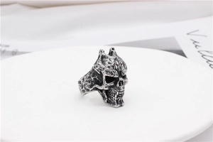 Detailed close-up of retro silver skull ring with gothic punk texture on white plate