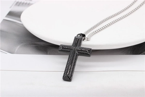 Gros plan du pendentif croix noire avec motif diamant et chaîne en acier argenté