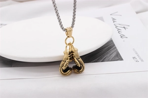 Detail of a vintage golden boxing glove pendant with silver box chain on a magazine