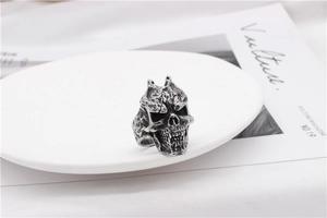 Close-up of gothic skull ring in vintage silver finish with a red stone eye detail