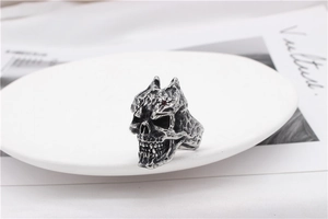 Macro shot of vintage skull ring with red gemstone eye on minimalist white ceramic plate