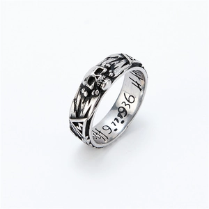 Macro detail of vintage skull ring featuring engraved date and intricate antique patterns