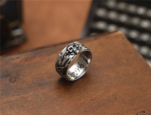 Macro detail of gothic skull ring with engraved numbers on rustic wooden background