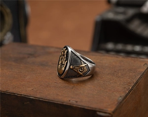 Détail macro du symbole maçonnique et du relief de paume sur une bague en acier vintage