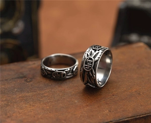 Close-up of vintage punk skull ring with feather textures and star symbols on wood
