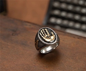 Vue macro de la bague maçonnique en acier inoxydable avec paume dorée sur bois
