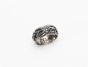 Detailed macro view of vintage gothic cross ring with skull relief and interior engraving
