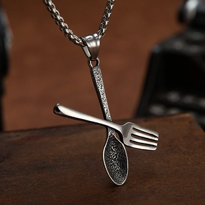 Creatieve lepel en vork hanger ketting van roestvrij staal op vintage houten achtergrond