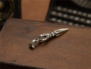 Macro detail of vintage stainless steel religious dagger pendant on dark wooden box