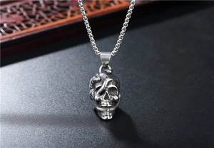 Détail macro du pendentif crâne et serpent gothique avec finition acier vintage sur chaîne