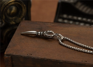 Macro shot of retro stainless steel Vajra pestle pendant with textured box chain detail