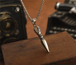Macro shot of a vintage silver vajra pestle necklace on a retro wooden background