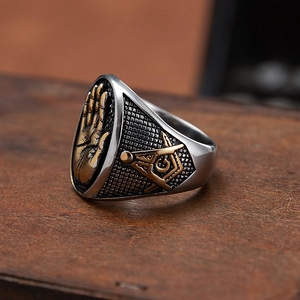 Bague maçonnique vintage en acier avec palmier doré et boussole sur fond de bois