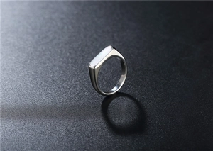 Macro detail of silver stainless steel signet ring with a white shell inlay on black base