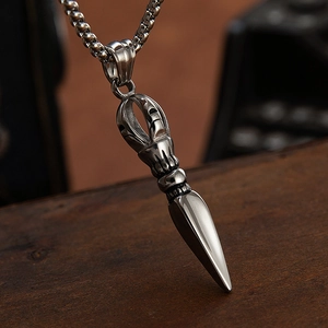 Vintage stainless steel Vajra Pestle pendant necklace on rustic wooden background