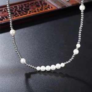 Collier hip hop en perles et acier titane avec billes argentées sur surface noire