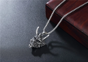 Macro shot of silver Hannya mask pendant in retro titanium steel with cubic link chain