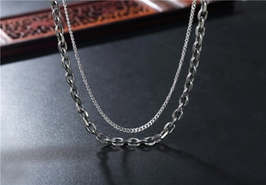 Macro detail of layered stainless steel double chain necklace with vintage silver finish