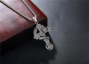 Macro shot of vintage dragon wrapping around a gothic cross pendant with skull details