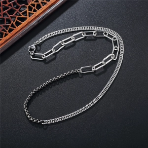 Collier chaîne argentée à maillons mixtes et trombones sur fond sombre avec éventail