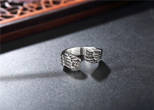 Detailed macro shot of vintage silver feather wing texture on adjustable steel ring