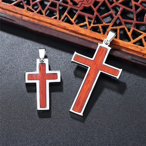 Stainless steel religious cross necklace with wood inlay on black textured background